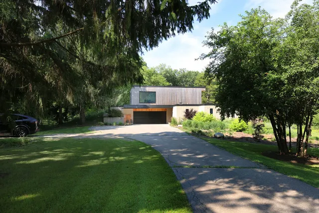 a front view of a house with a yard and tree