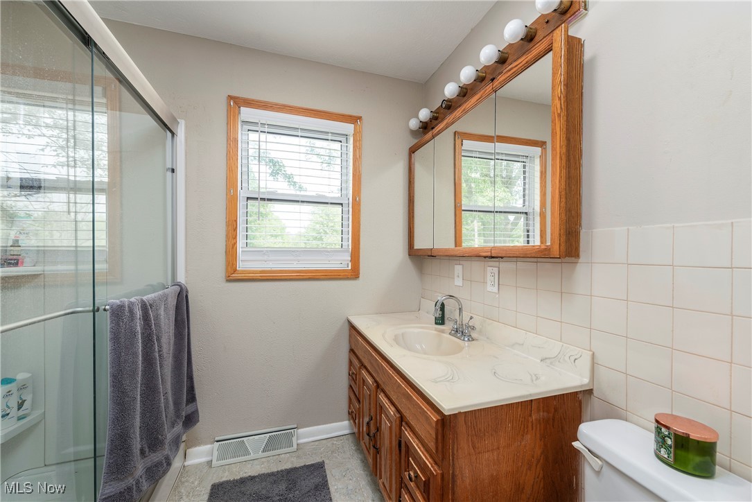 7835 Elyria Road Medina, OH 44256 - Photo 14 of 46 Full bathroom with vanity, healthy amount of natural light, a shower with shower door, and toilet