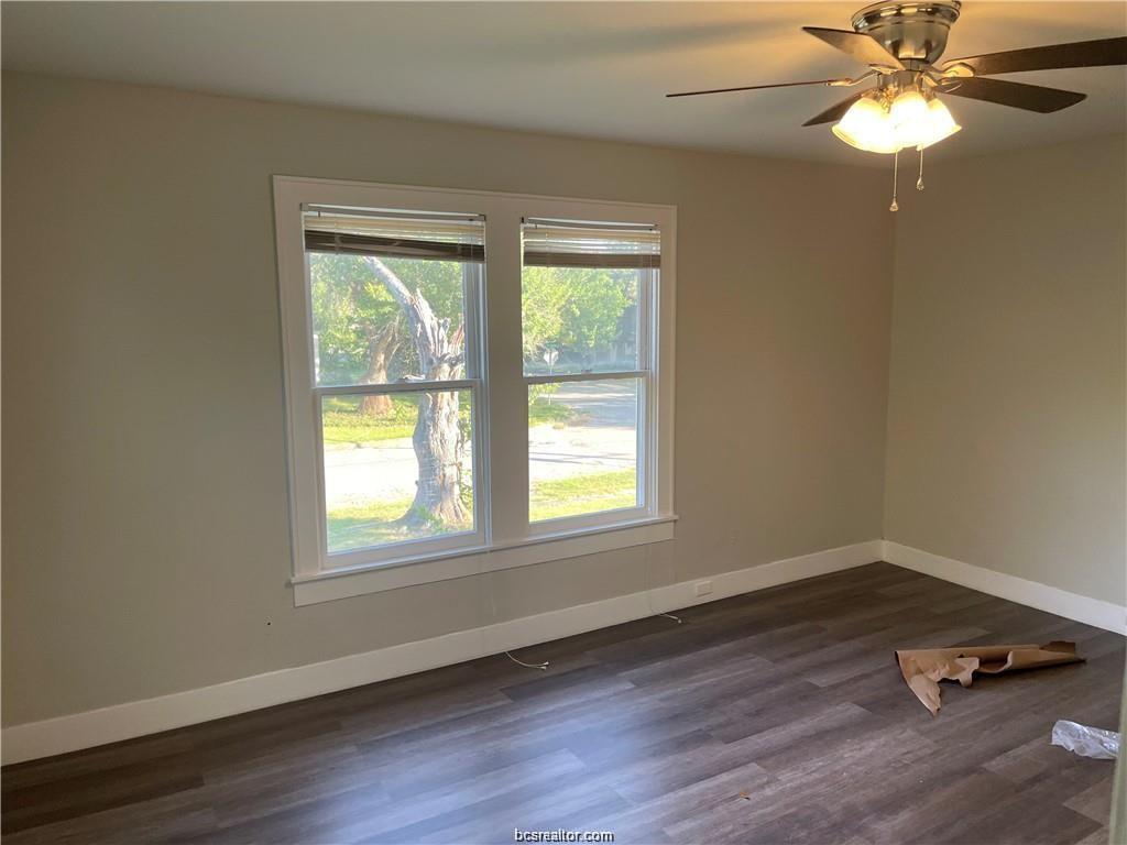 803 McAlpine Street Navasota, TX 77868 - Photo 2 of 7 a view of an empty room with wooden floor and a window