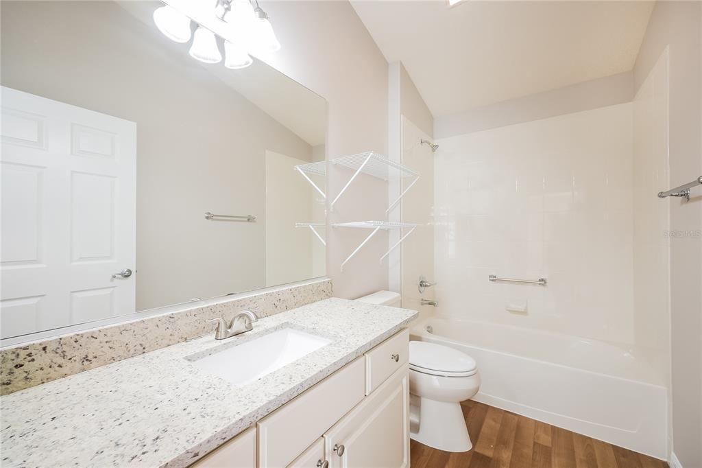 2294 Trailwinds Terrace The Villages, FL 32162 - Photo 13 of 16 a bathroom with a granite countertop sink a toilet and shower
