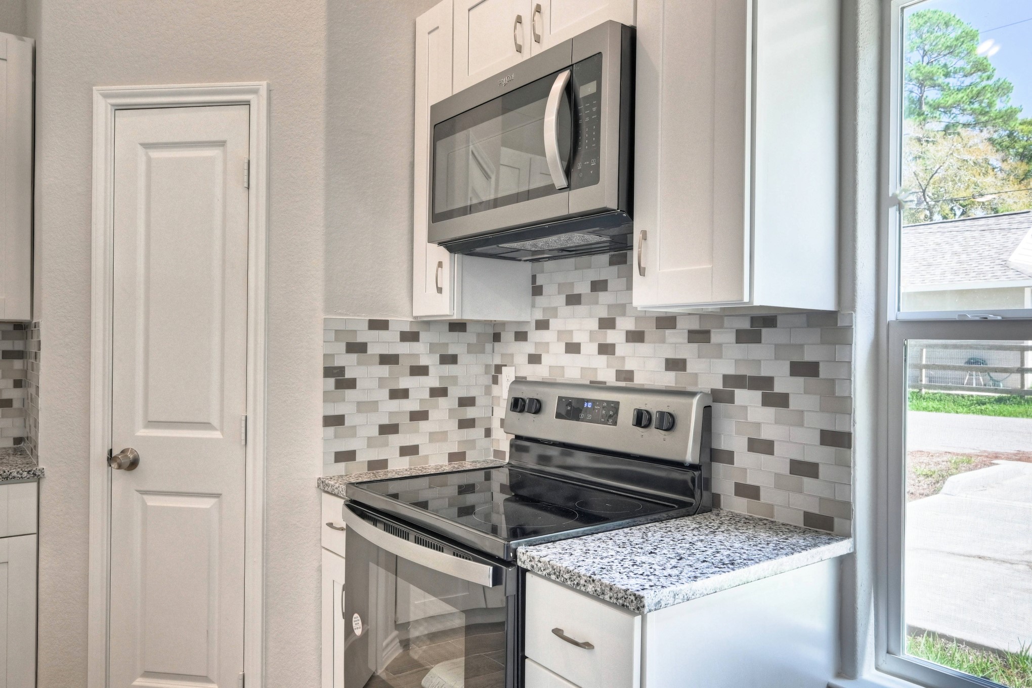 9812 Arbor Oak Willis, TX 77318 - Photo 7 of 40 a kitchen with granite countertop a stove sink and cabinets