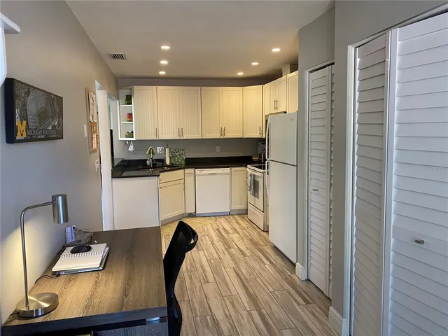 a kitchen with stainless steel appliances granite countertop a refrigerator and a stove top oven