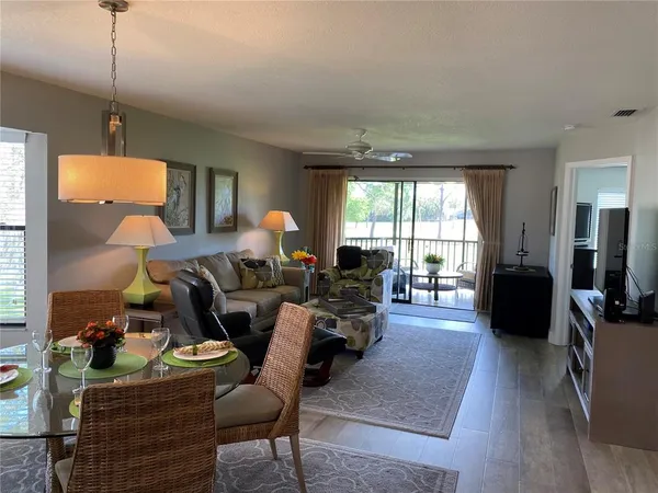 a living room with furniture a flat screen tv and wooden floor