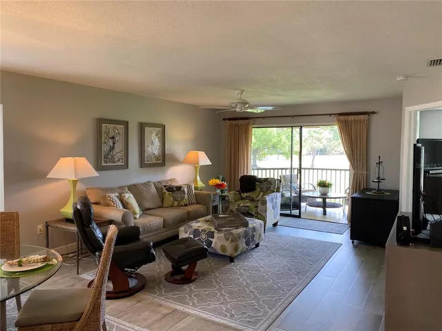 a living room with furniture flat screen tv and window