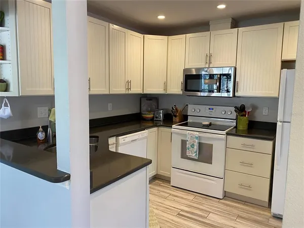 a kitchen with stainless steel appliances granite countertop a sink a stove and a refrigerator