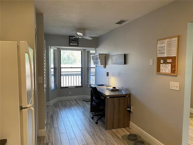 a view of a workspace with wooden floor and a window