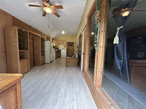 a view of a hallway view with wooden floor and a kitchen