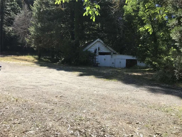 a view of a house with a backyard and wooden fence