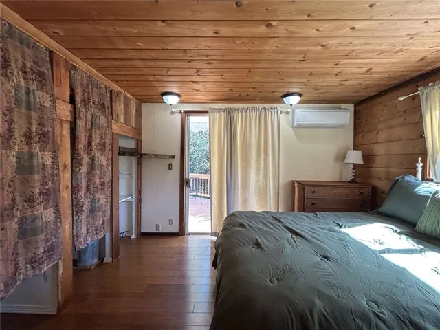 a bedroom with bed and wooden floor
