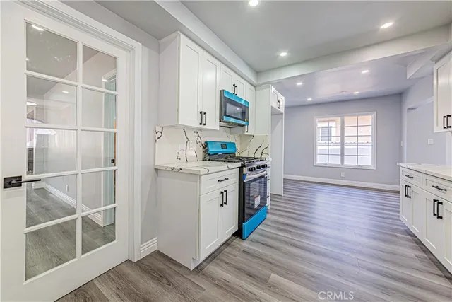 an empty room with windows chandelier and fireplace
