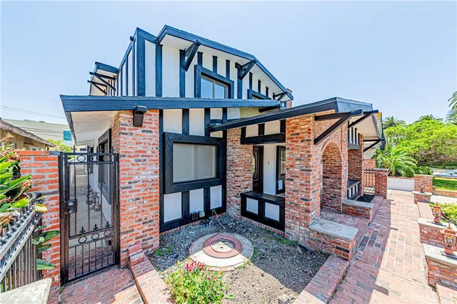 a front view of building with a garden and swimming pool