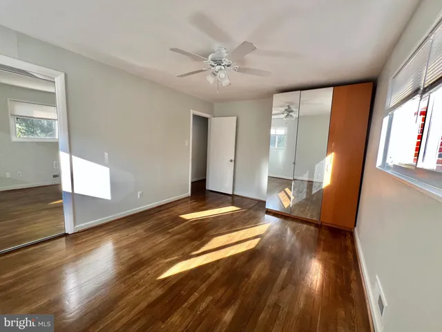 a view of a livingroom with wooden floor and a ceiling fan