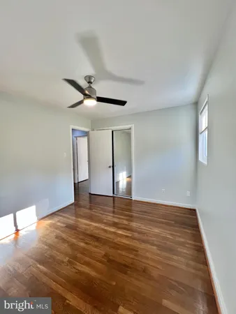 a view of an empty room with window and a ceiling fan