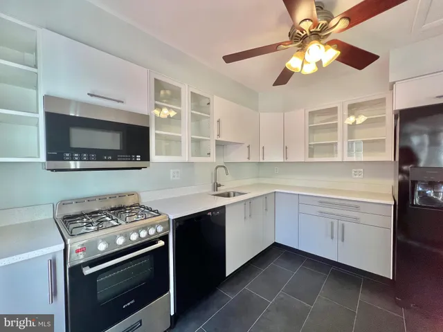 a kitchen with stainless steel appliances a sink a stove and cabinets