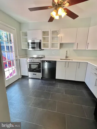 a kitchen with stainless steel appliances a stove a sink and a microwave