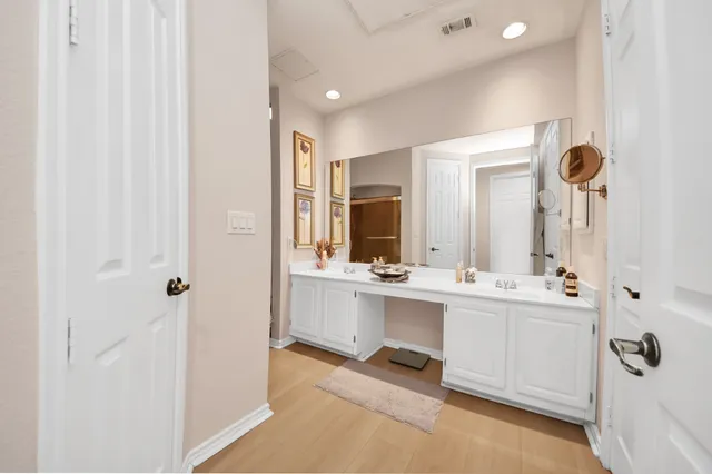 a bathroom with a double vanity sink a mirror and a bathtub