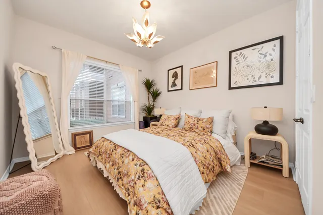 a bedroom with a bed and a window with chair