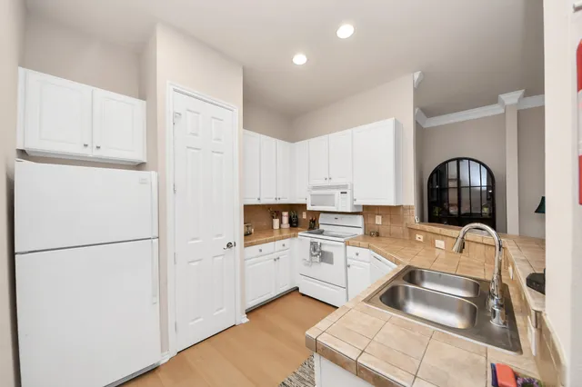 a kitchen with white cabinets and white appliances