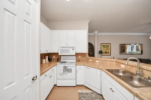 a kitchen with granite countertop a sink stove and cabinets
