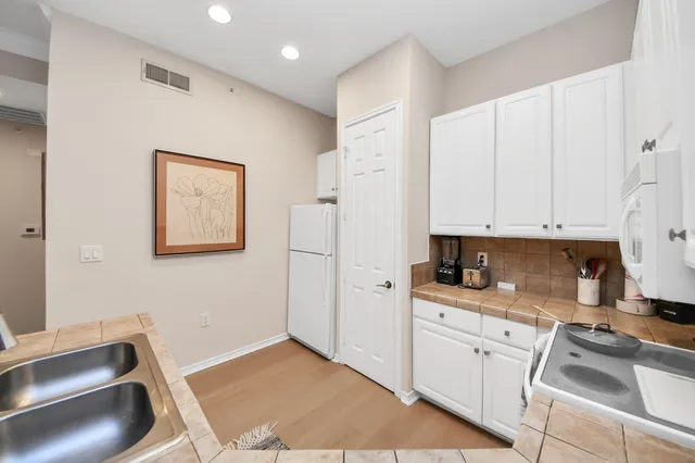 a kitchen with granite countertop a sink stove and cabinets