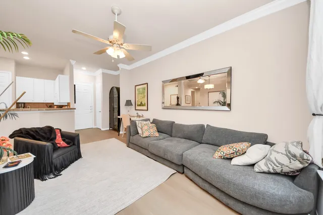 a living room with furniture and a ceiling fan