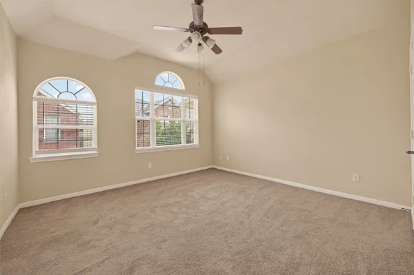 an empty room with windows and fan