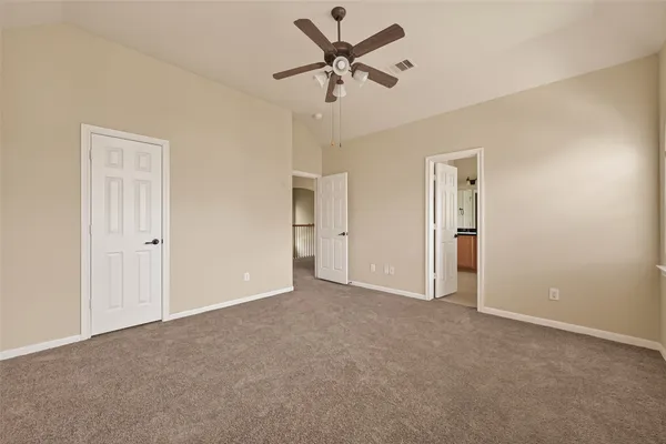 an empty room with closet and a ceiling fan