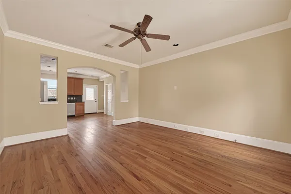 a view of empty room with wooden floor and ceiling fan