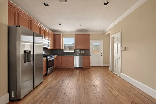 a kitchen with stainless steel appliances a refrigerator sink and cabinets