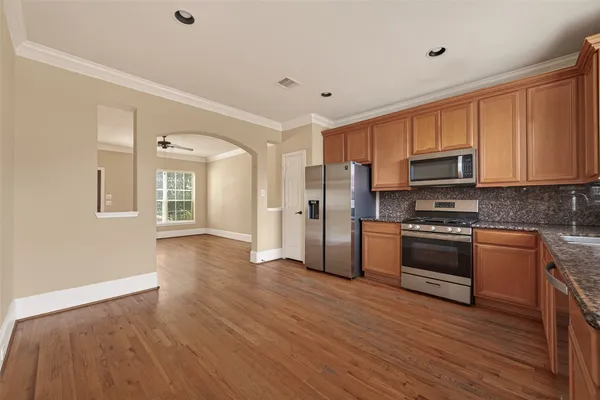 a kitchen with granite countertop a refrigerator and a stove top oven