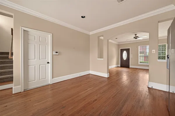 a view of an empty room with wooden floor and a window