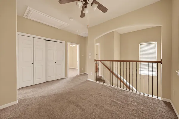 a view of a hallway with a chandelier fan