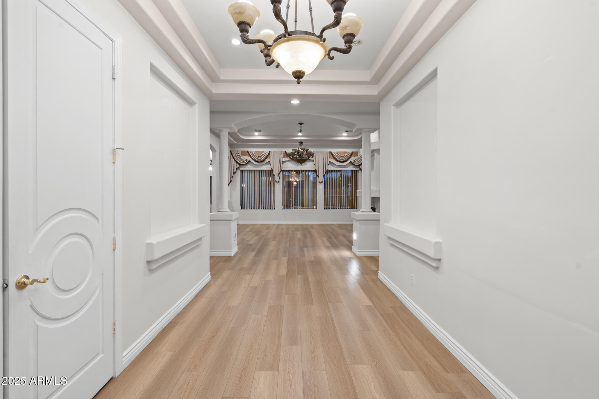 6829 North 14th Street Phoenix, AZ 85014 - Photo 11 of 53 a view of a hallway with wooden floor and chandelier