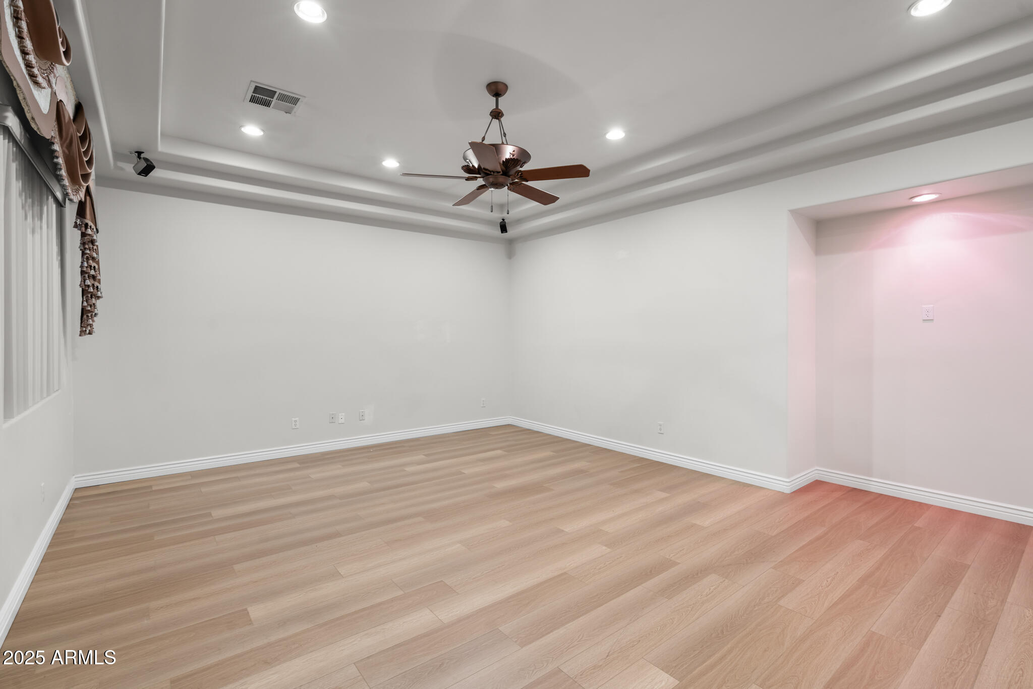 6829 North 14th Street Phoenix, AZ 85014 - Photo 14 of 53 an empty room with wooden floor ceiling fan and window