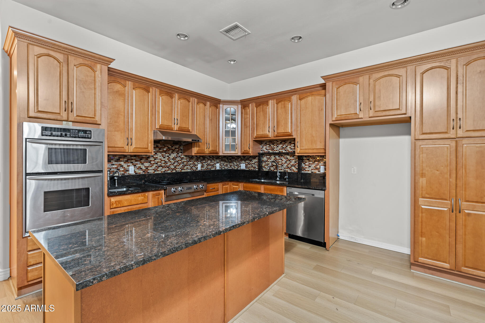 6829 North 14th Street Phoenix, AZ 85014 - Photo 21 of 53 a kitchen with stainless steel appliances granite countertop a refrigerator a stove and a sink with wooden floors