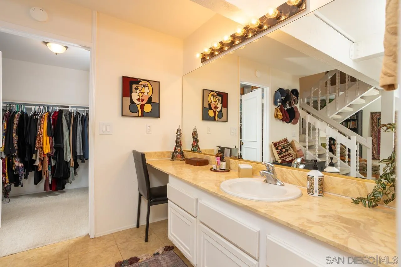 2412 Altisma Way, Unit D Carlsbad, CA 92009 - Photo 27 of 46 a bathroom with a granite countertop sink and a mirror