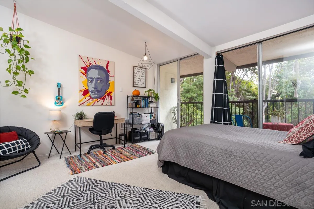 2412 Altisma Way, Unit D Carlsbad, CA 92009 - Photo 35 of 46 a bedroom with a bed a large window with table and chairs