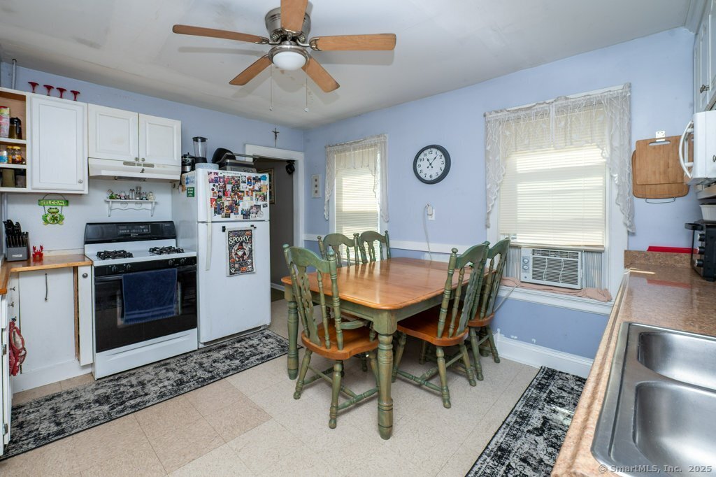 21 Poplar Street Waterbury, CT 06708 - Photo 8 of 31 a kitchen with stainless steel appliances kitchen island granite countertop a dining table chairs and a refrigerator
