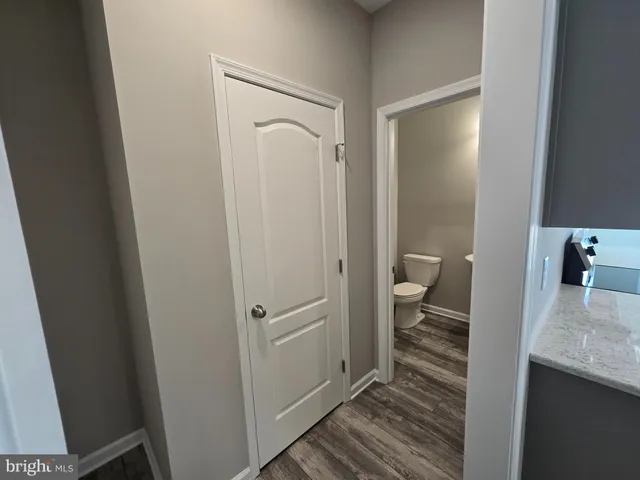 a bathroom with a granite countertop sink a toilet and a shower