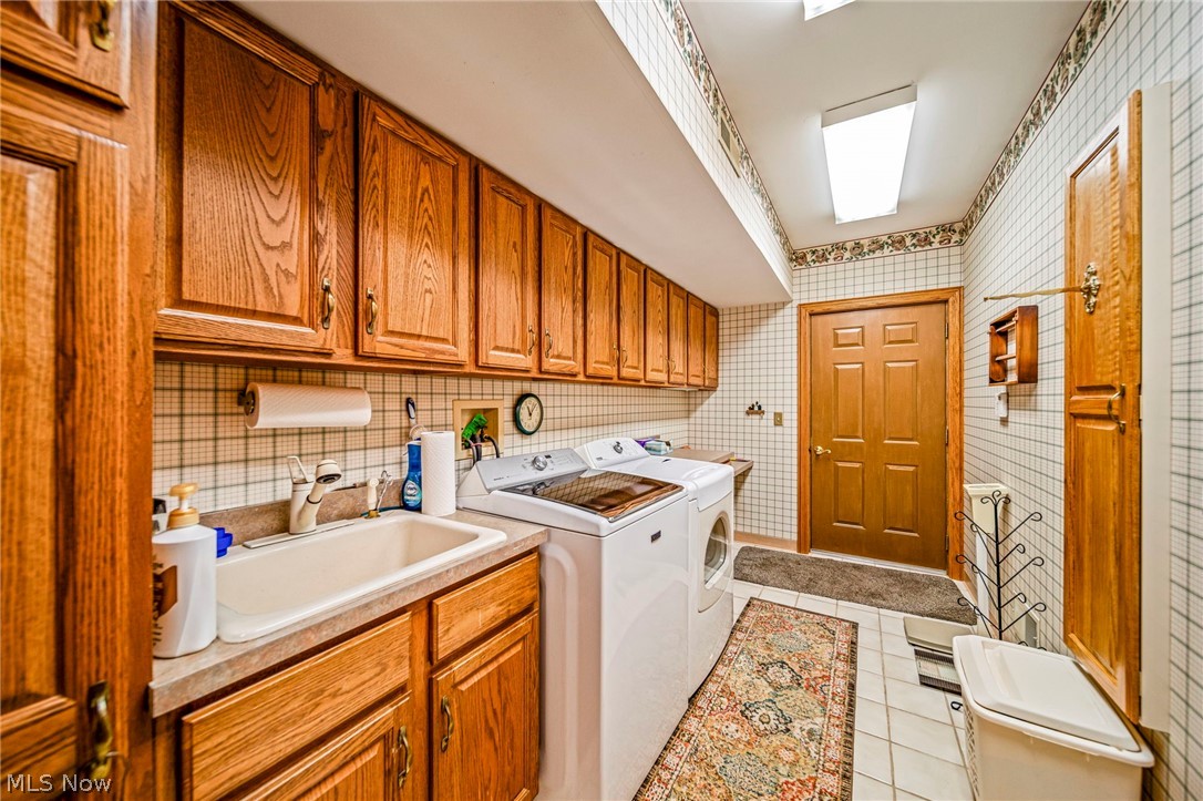 8801 Bunker Road Orwell, OH 44076 - Photo 17 of 50 Washroom with light tile patterned floors, independent washer and dryer, and cabinet space