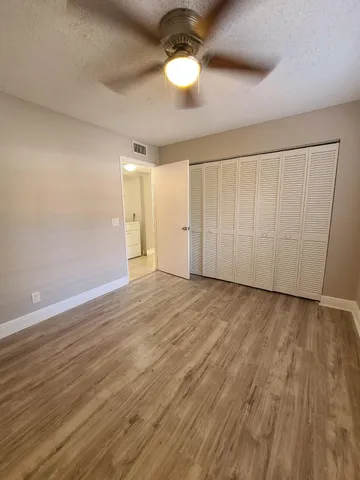 a view of an empty room and chandelier fan