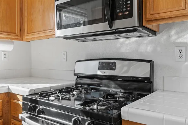 a kitchen with a refrigerator and a stove top oven