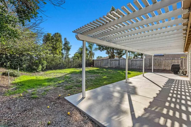 a view of a tree in front of yellow house