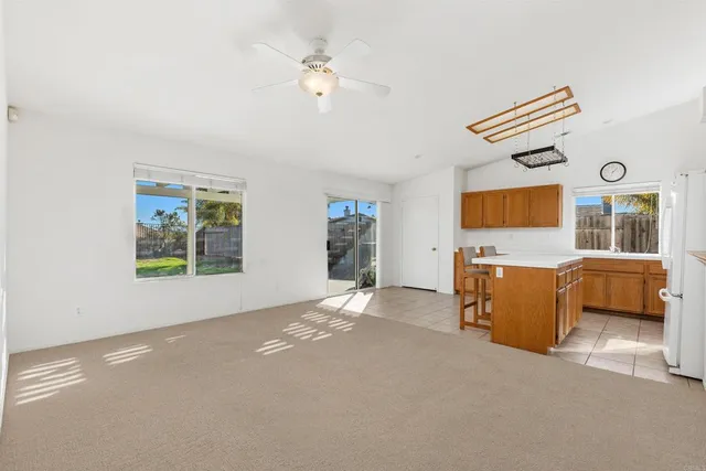a kitchen with a refrigerator a stove cabinets and a dining table