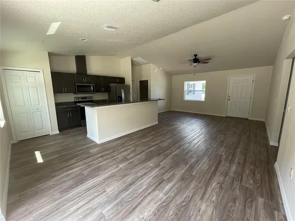 a view of kitchen living room with wooden floor and window