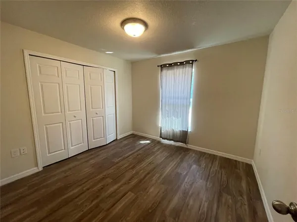 a view of an empty room with wooden floor