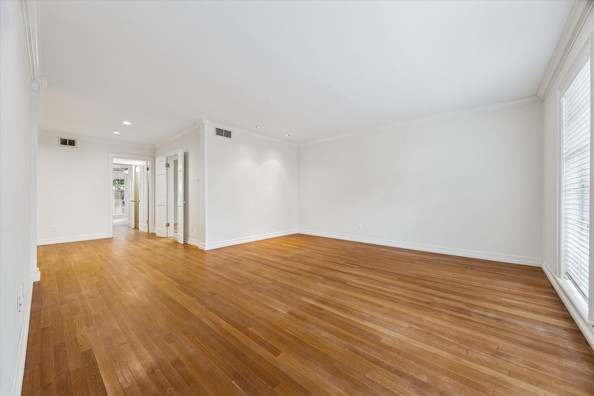 a view of an empty room with wooden floor