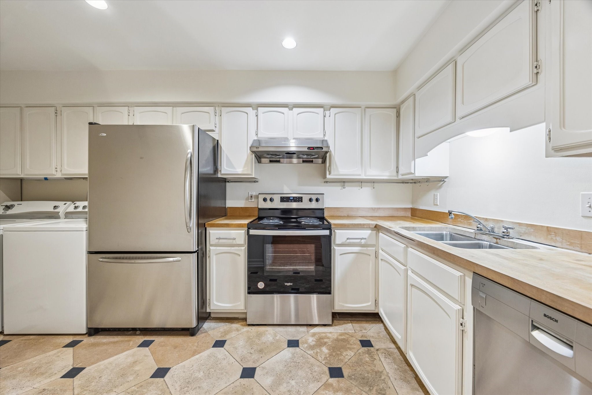 453 North Post Oak Lane Houston, TX 77024 - Photo 5 of 18 a kitchen with a refrigerator sink stove and cabinets