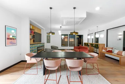 a kitchen with a dining table chairs and white cabinets