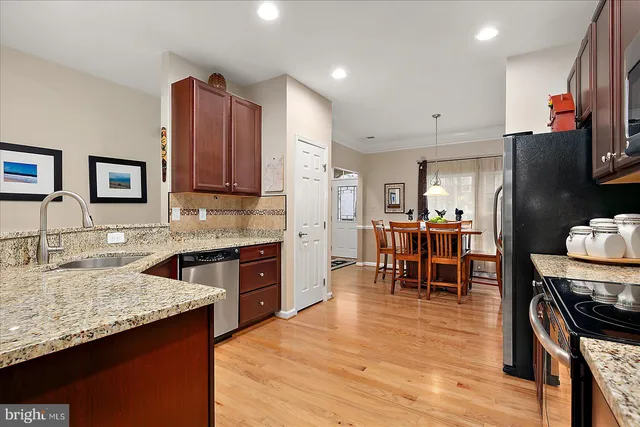 a kitchen with stainless steel appliances granite countertop wooden cabinets a stove top oven and granite counter tops